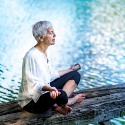 Dr Kirsten Deutschländer - Frau meditiert am Wasser