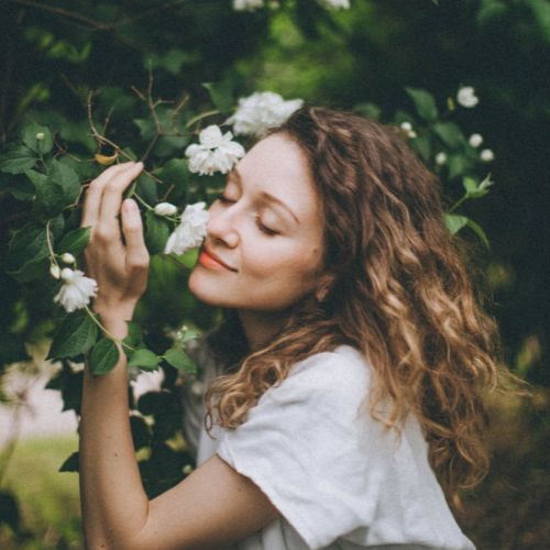 Pangera-Barbara Vasiljevic-frau schmiegt sich an blumen